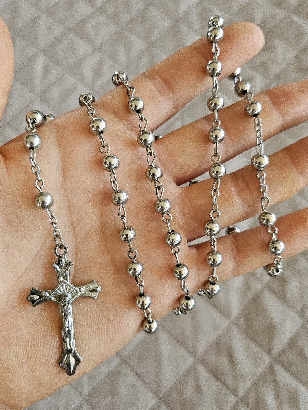 Silver toned rosary, not actual silver beads are plastic.